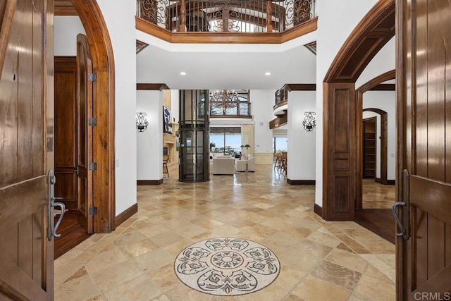 5015 Rancho Quinta Bnd, San Diego, CA 92130 - foyer entrance featuring arched walkways, a high ceiling, stone tile flooring, and recessed lighting