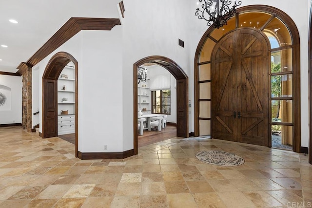 5015 Rancho Quinta Bnd, San Diego, CA 92130 - entrance foyer featuring stone tile flooring, recessed lighting, arched walkways, a chandelier, and ornamental molding