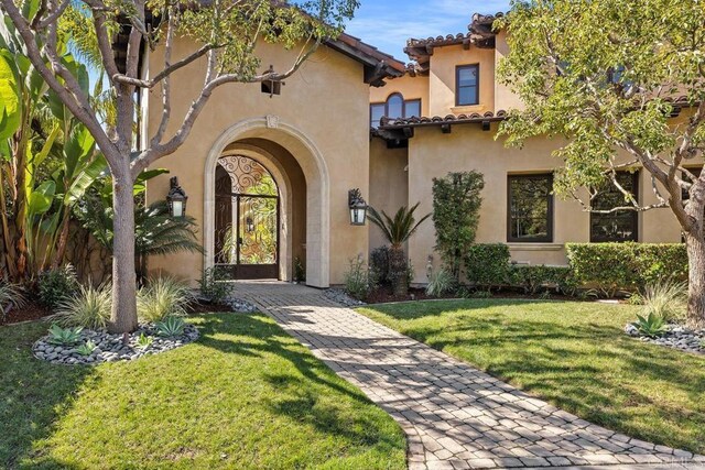 5015 Rancho Quinta Bnd, San Diego, CA 92130 - doorway to property with a lawn, stucco siding, and a tile roof