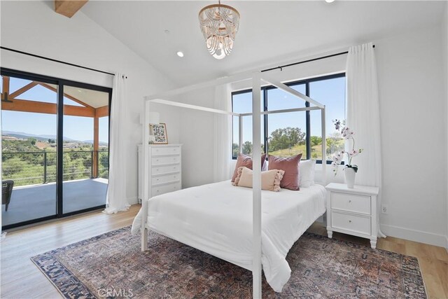 bedroom featuring multiple windows, lofted ceiling, a notable chandelier, and access to outside