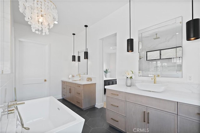 bathroom with tile patterned flooring, a sink, two vanities, a freestanding tub, and a notable chandelier