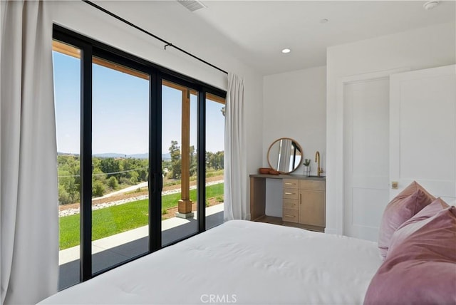 bedroom with wet bar, access to outside, and multiple windows