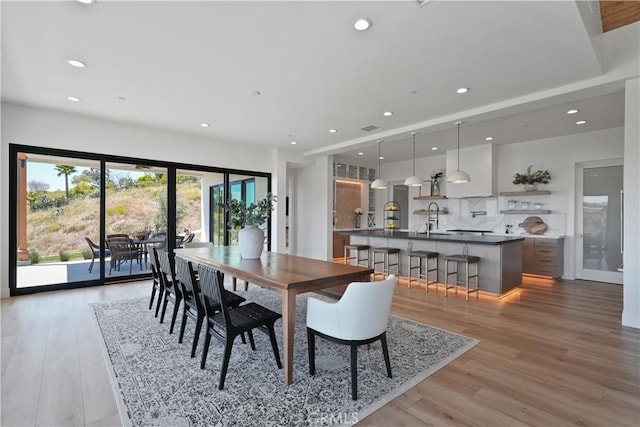 dining area with light wood-style flooring and recessed lighting