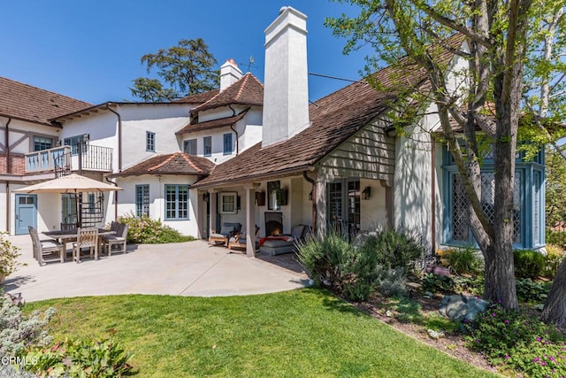 233 Hillside Rd, South Pasadena, CA 91030 - back of house featuring stucco siding, a chimney, a patio area, and a lawn