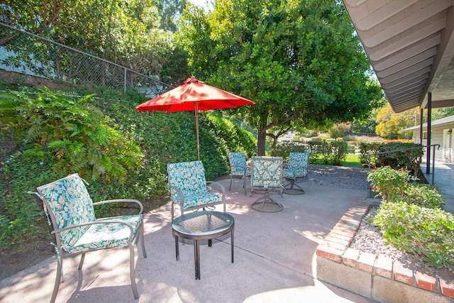 view of patio / terrace with a fire pit, outdoor dining space, and fence