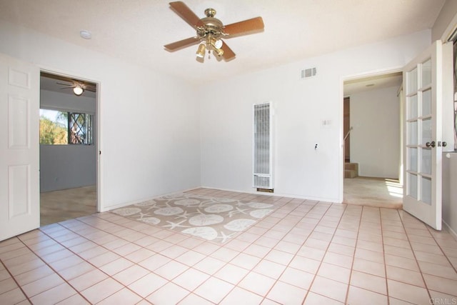 spare room with stairway, ceiling fan, and visible vents