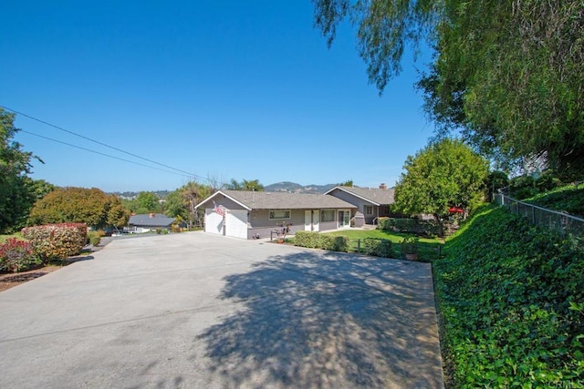 ranch-style house featuring a garage and fence