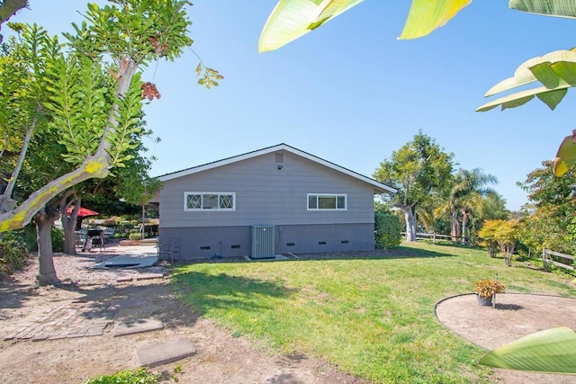 rear view of house featuring a patio area, a lawn, and crawl space
