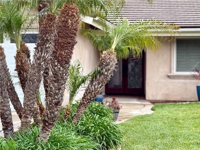 9033 Mandarin Ave, Rancho Cucamonga, CA 91701 - view of exterior entry featuring stucco siding, french doors, and a yard