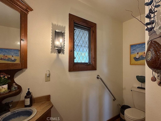 half bathroom featuring toilet and a sink