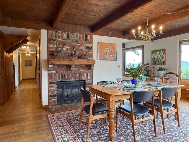 dining area with light wood-style floors, beam ceiling, wood ceiling, and a healthy amount of sunlight