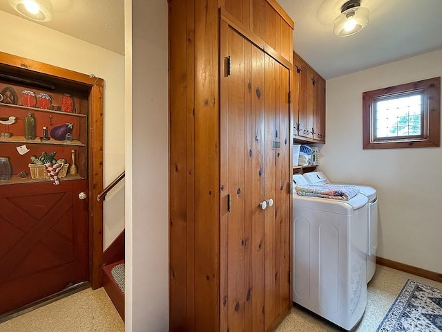 laundry area featuring washing machine and clothes dryer and cabinet space
