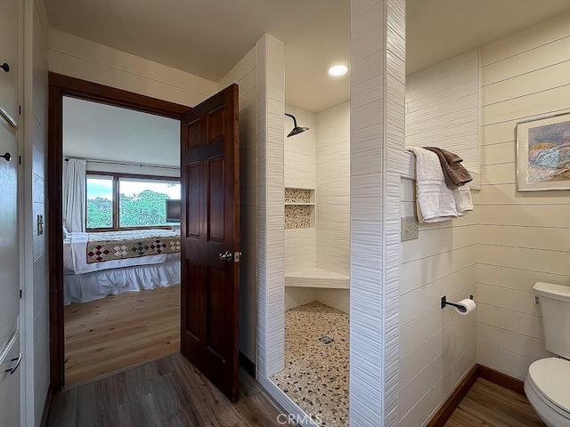 full bathroom featuring ensuite bath, a tile shower, toilet, and wood finished floors