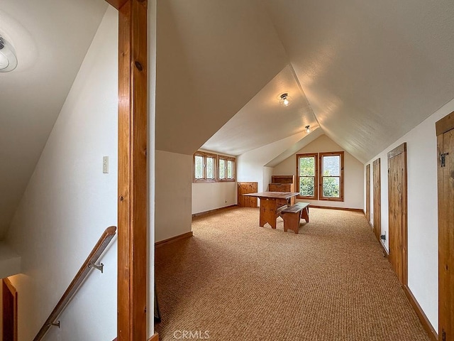 additional living space featuring vaulted ceiling, baseboards, and light colored carpet