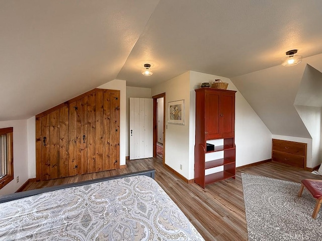 bonus room with lofted ceiling, wood finished floors, and baseboards