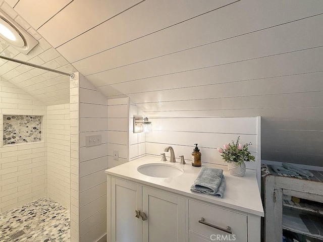 bathroom with vaulted ceiling, vanity, and a shower stall