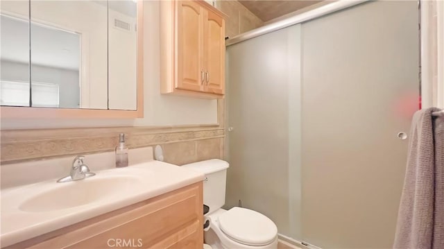 full bath featuring vanity, toilet, visible vents, and a stall shower