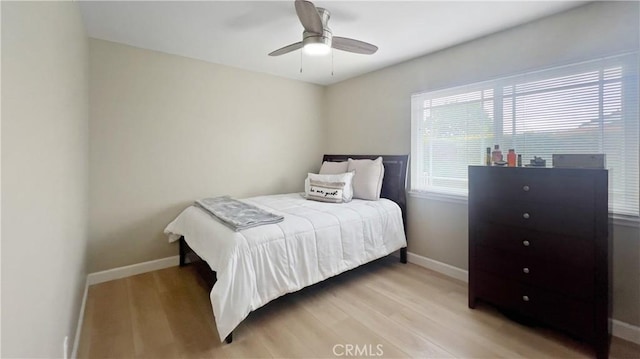 bedroom featuring light wood-type flooring, baseboards, and a ceiling fan