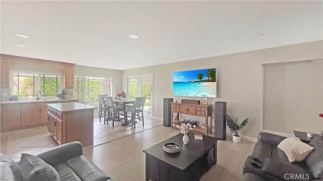 living area featuring baseboards, light tile patterned floors, and recessed lighting