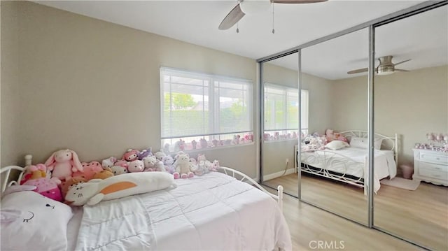 bedroom featuring light wood-style floors, a closet, and ceiling fan