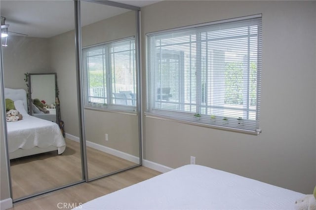 bedroom featuring baseboards, a closet, and wood finished floors