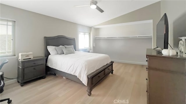 bedroom with vaulted ceiling, light wood-style flooring, baseboards, and ceiling fan