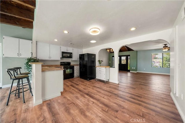 12521 Mcferon Rd, Poway, CA 92064 - kitchen with black appliances, arched walkways, open floor plan, recessed lighting, and wood finished floors