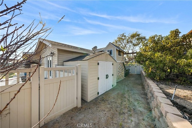 12521 Mcferon Rd, Poway, CA 92064 - view of side of property with a gate, an outbuilding, and a storage shed