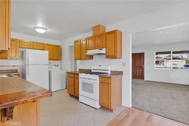 305 Beverly Ave, Barstow, CA 92311 - kitchen featuring washer / dryer, white appliances, under cabinet range hood, and light carpet