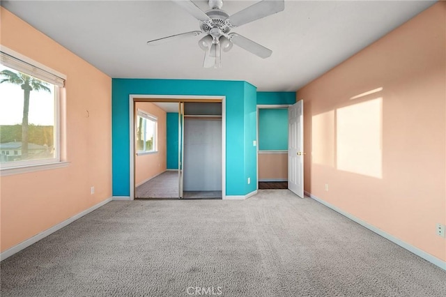 unfurnished bedroom featuring ceiling fan, carpet floors, a closet, and baseboards