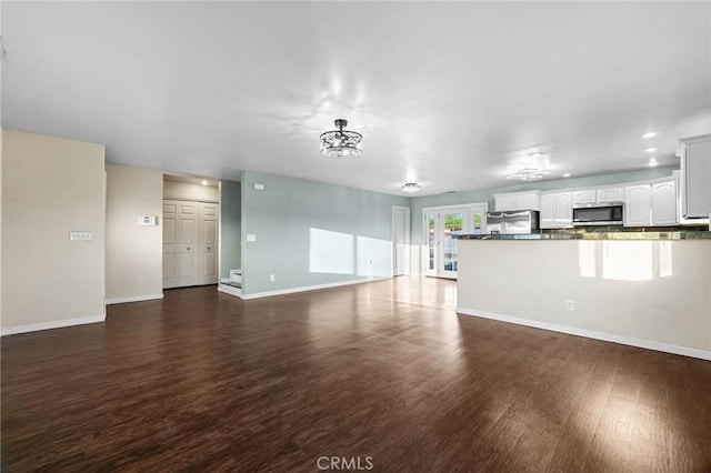 unfurnished living room featuring dark wood-type flooring, baseboards, and recessed lighting