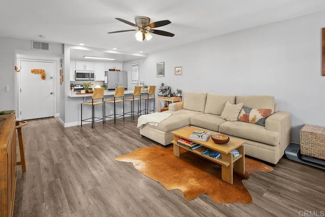 living room with ceiling fan, recessed lighting, visible vents, and wood finished floors