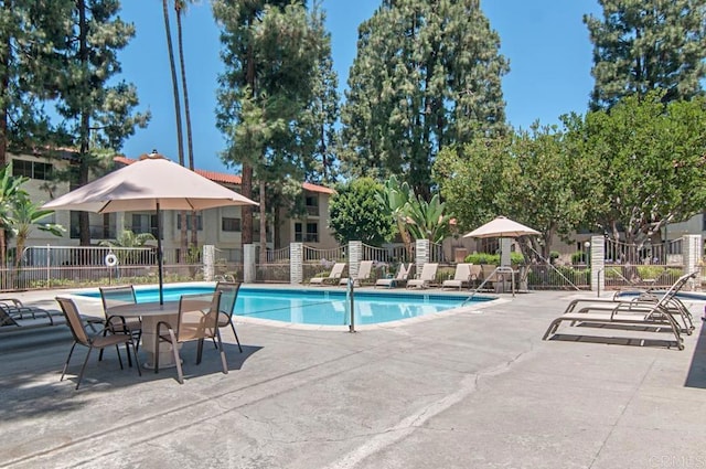 pool with fence and a patio