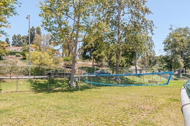 view of home's community with a yard and fence
