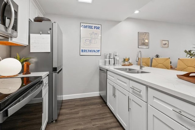 kitchen with recessed lighting, dark wood finished floors, a sink, white cabinetry, and appliances with stainless steel finishes