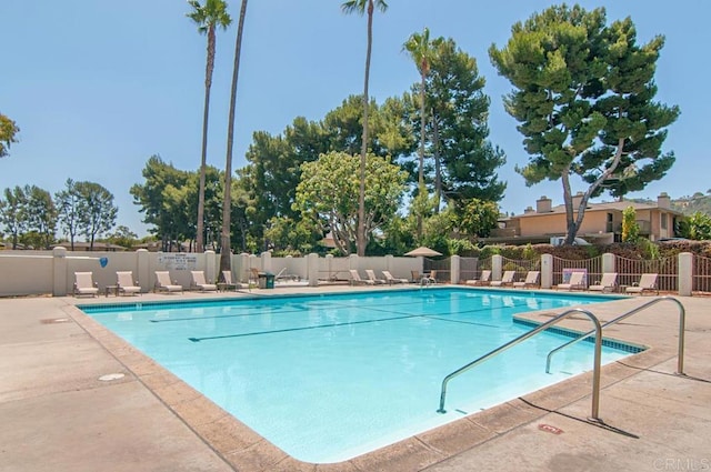 community pool featuring a patio and fence
