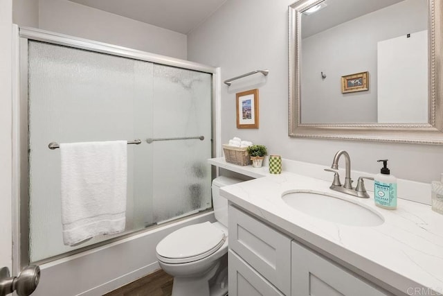 bathroom with vanity, toilet, shower / bath combination with glass door, and wood finished floors