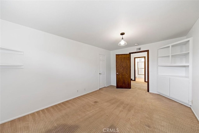 unfurnished room featuring light carpet and baseboards