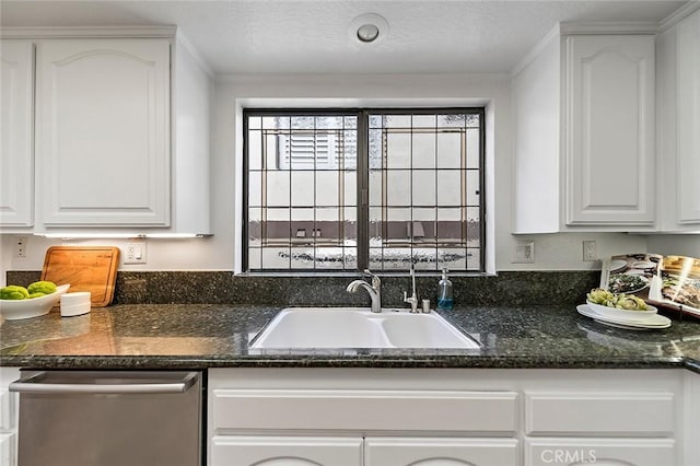 kitchen with dark stone counters, crown molding, a sink, dishwasher, and white cabinets
