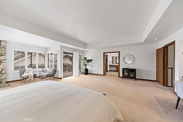 bedroom with a fireplace, baseboards, light colored carpet, and a tray ceiling