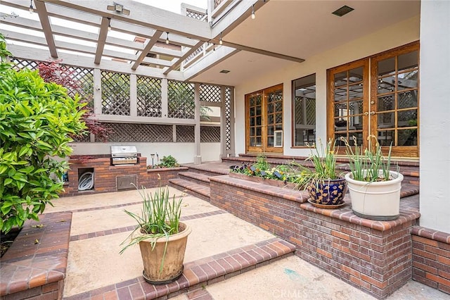view of patio / terrace featuring area for grilling, a pergola, and exterior kitchen