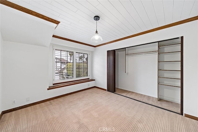 unfurnished bedroom featuring light colored carpet, baseboards, ornamental molding, and a closet
