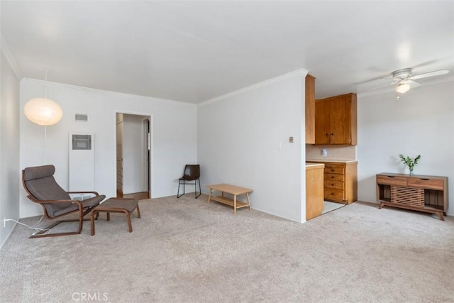 sitting room with visible vents, a ceiling fan, light colored carpet, and ornamental molding