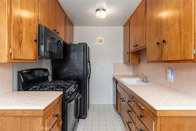 kitchen featuring a sink, backsplash, brown cabinets, light floors, and black appliances