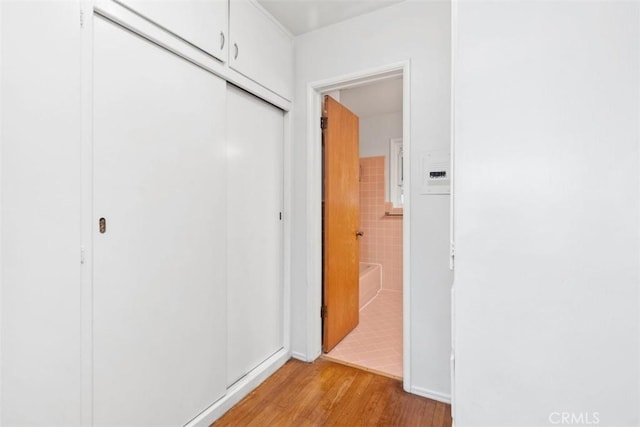 hallway featuring tile walls and light wood-style flooring
