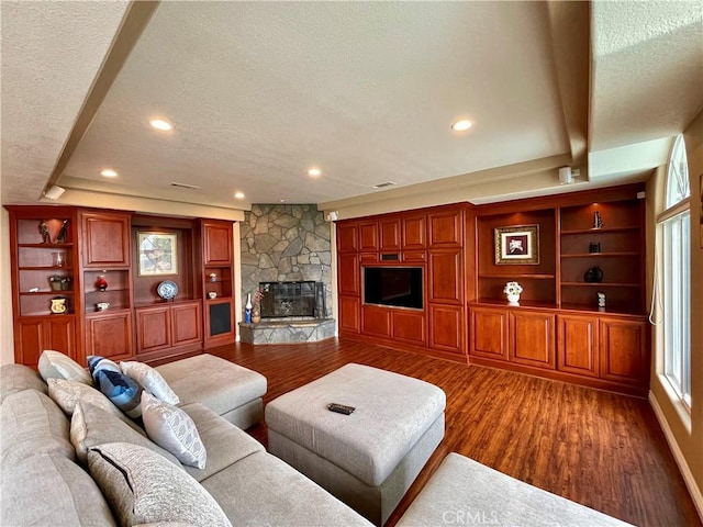 living area with a fireplace, wood finished floors, and a textured ceiling