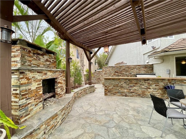 view of patio / terrace with an outdoor kitchen and an outdoor stone fireplace