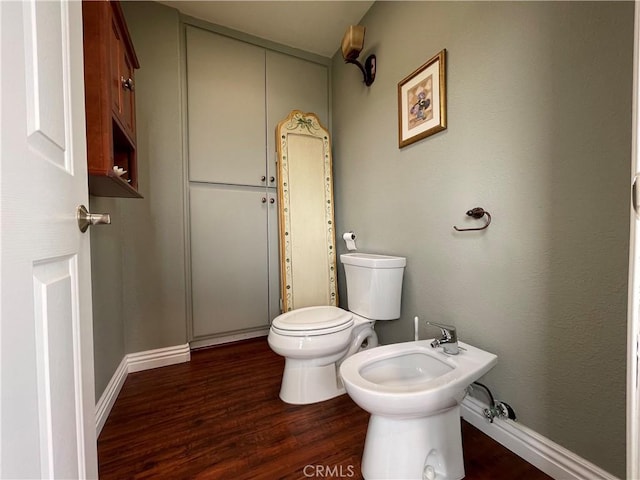 bathroom featuring wood finished floors, a bidet, and toilet
