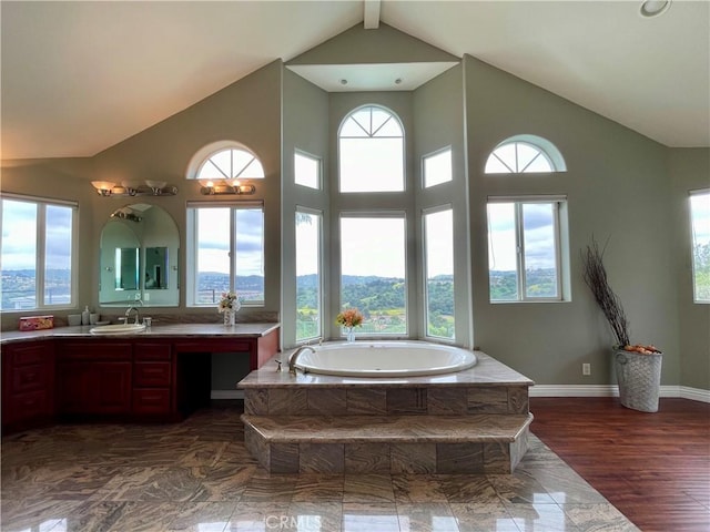 full bath with high vaulted ceiling, a bath, baseboards, and vanity