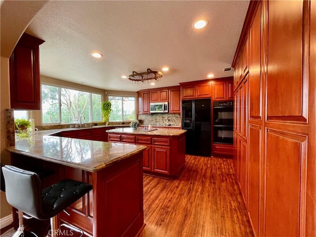 21062 Quail Run Dr, Diamond Bar, CA 91789 - kitchen featuring black appliances, recessed lighting, a textured ceiling, dark wood-style floors, and a peninsula